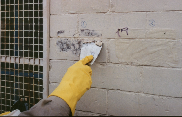 Masonry paint, softened by Safer* Paint & Varnish Remover being removed with a scrapper
